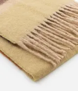 Bufanda de tejido tipo franela con diseño de bloques de color en tonos tierra y flecos en los extremos.