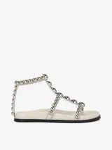 Sandalias planas color blanco con tiras decoradas con tachas plateadas y cierre de velcro.