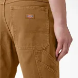 Pantalón de trabajo Dickies color marrón, de corte recto y holgado, confeccionado en lona de algodón prelavada. Cuenta con múltiples bolsillos y presilla para martillo.