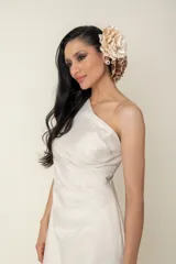 Vestido largo de fiesta color marfil/champagne, confeccionado en lurex. Diseño drapeado con un solo hombro.