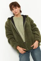 Campera tipo canguro teddy negra con capucha y cierre. El forro es de felpa color verde militar.