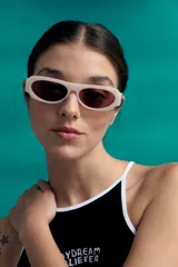 Lentes de sol con marco robusto de silueta rectangular, color blanco hueso o crema, y cristales tintados en tono rojizo/rosado.