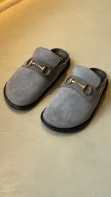 Mocasines color marrón de cuero gamuzado con detalle de hebilla dorada.