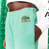 Pantalón de jogging verde agua con cintura elástica y puños ajustados. Presenta un logo de Lacoste y Minecraft en el muslo.