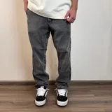 Jean de corte recto con acabado lavado en tono gris oscuro, confeccionado en denim resistente con diseño de cinco bolsillos.