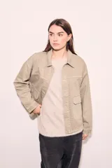 Sobrecamisa color beige de algodón con bordados en cuello, solapa, cierre y puños.