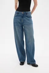 Pantalon jean de corte barrel y tiro medio, en color negro, con diseño de pierna ancha y estructura rígida.