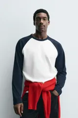 Camiseta de corte relajado con cuello redondo y mangas largas tipo raglán en contraste de color.