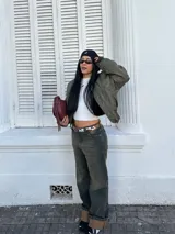 Pantalón de jean de tiro alto con lavado oscuro y detalles de desgaste.