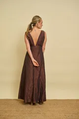 Vestido largo azul con textura arrugada, escote en V pronunciado, sin mangas y falda evasé.