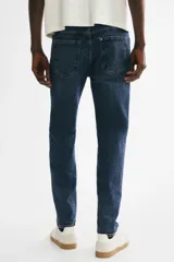 Jean de cinco bolsillos en denim de algodón, de corte estándar y piernas ajustadas, con lavado azul y efecto deslavado.