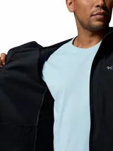 Campera softshell híbrida Columbia Trailborne para hombre, de color negro, con capucha, cierre frontal y bolsillos con cremallera. Cuenta con tecnología Omni-Shield de repelencia al agua y detalles reflectantes.