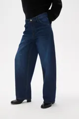 Pantalon jean de corte barrel y tiro medio, en color negro, con diseño de pierna ancha y estructura rígida.