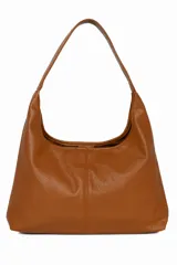 Cartera tipo hobo de cuero sintético color marrón, con diseño de hombro único y textura granulada.