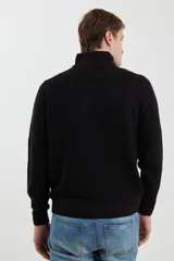 Sweater verde de punto inglés con cuello alto y cierre metálico frontal. Tiene mangas largas y terminaciones en punto canalé.