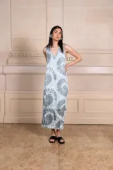 Vestido largo de seda color amarillo con estampado batik en tonos verde oliva y blanco. Escote en V con ribete de punto fino en cuello y mangas. Talle único.