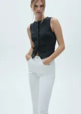Jeans de tiro medio con diseño capri, confeccionados en tejido de algodón estilo tejano. Presentan cierre de cremallera y botón, trabillas para cinturón, cinco bolsillos y bajo con aberturas laterales.