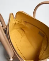 Cartera Flavia color beige de símil cuero con textura granulada, doble asa de mano y correa larga ajustable y desmontable. Cuenta con cierre superior y detalles de herrajes dorados.