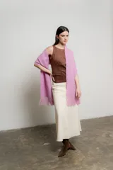 Bufanda tejida color rosa con flecos en los extremos.