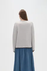 Cardigan de viscosa color marrón, con cuello en V, cierre frontal con botones y detalle de costura decorativa en contraste a lo largo de los bordes.
