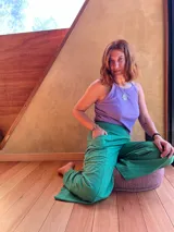 Pantalón tipo palazzo de tiro alto, confeccionado en jersey de algodón color verde. Presenta un diseño amplio con bolsillos laterales y una faja ancha en la cintura que proporciona soporte y ajuste.