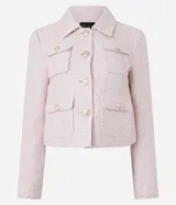 Campera corta de tweed color rosa, con cuello camisero, bolsillos delanteros con solapa y botones dorados estilo escudo.