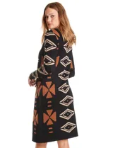 Vestido de punto con diseño integrado que simula un conjunto de vestido negro liso con un cárdigan largo estampado con patrón geométrico de eslabones. Presenta escote redondo y mangas largas.