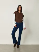 Jean de corte bootcut color azul oscuro, con tiro medio, bolsillos clásicos y cierre frontal con botón y cremallera.