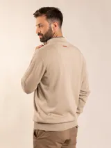 Sweater de punto en color gris claro, con cuello alto y medio cierre frontal. Presenta puños y ruedo acanalados para un ajuste cómodo.