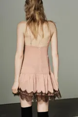 Vestido corto de tirantes finos ajustables con escote en pico. Presenta detalles de encaje en contraste en el escote y el ruedo. Cuenta con falda con vuelo y cierre de cremallera oculto en la espalda.