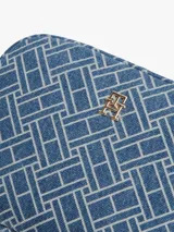 Cartera cruzada estilo cámara de Tommy Hilfiger, confeccionada en denim de algodón con estampado de monograma TH y detalles en cuero vacuno. Cuenta con cierre principal y herrajes metálicos dorados, incluyendo el monograma TH en el frente. Posee correa ajustable y extraíble.