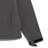 Campera softshell de hombre, color gris oscuro, con capucha ajustable, cierre frontal y bolsillo vertical en el pecho con ribete reflectante. Presenta un pequeño parche con logo en la manga.