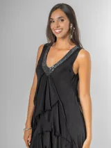 Vestido largo negro de seda con escote en V adornado con lentejuelas plateadas. Presenta un diseño de capas superpuestas con terminaciones deshilachadas que aportan volumen y movimiento. Es de corte sin mangas con breteles anchos y espalda elastizada.
