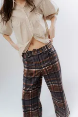 Pantalón de corte recto con estampado a cuadros en tonos marrones y rosados. Presenta una pretina elástica para mayor comodidad y está confeccionado en una tela acanalada con caída suave.