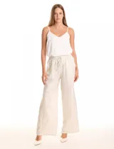 Pantalón wide leg de tela laminada metalizada color blanco, con pretina elástica y lazo de ajuste en la cintura. Cuenta con bolsillos laterales.