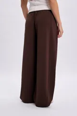 Pantalón deportivo marrón de corte barrel, estilo ancho y holgado, con cintura elástica.