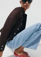 Pantalón de mezclilla de corte wide leg y tiro medio, con bolsillos y cierre frontal.