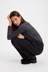 Polera de cuello alto y manga larga con estampado geométrico de rombos en tonos bordó y detalles en blanco.