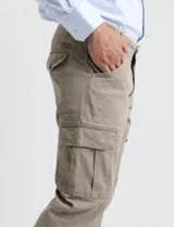 Pantalón cargo de algodón sarga con elastano, color verde militar. Presenta bolsillos laterales con fuelle, bolsillos traseros con tapa y botón, y costuras reforzadas en las rodillas.
