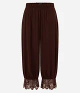 Pantalón bloomer marrón de cintura alta, confeccionado en viscosa con textura crinkle. Cuenta con un diseño amplio y cómodo, perneras voluminosas, puños con elástico interno y aplicación de encaje floral en los puños.