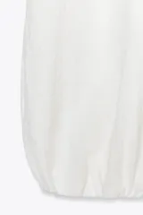 Pantalón blanco de tejido fluido, tiro medio con cintura elástica y bajo abullonado.