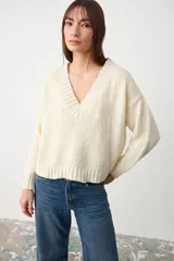 Sweater de tejido de punto color crudo, con escote en V y cuello acanalado, de diseño holgado y mangas largas.