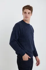 Sweater de escote redondo con manga larga, confeccionado en tejido moteado de textura suave.