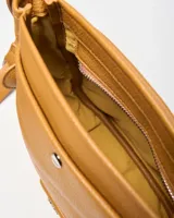 Bandolera de símil cuero color habano, con bolsillo frontal con broche a presión, correa ajustable y logo de la marca en placa metálica.