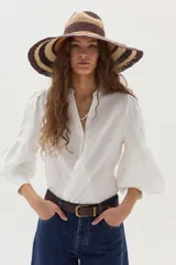 Camisa de lino blanca con cuello mao, escote en V y mangas largas abullonadas con puños ajustados.