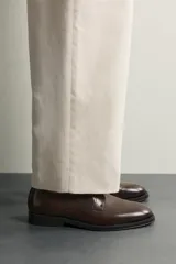 Zapato de vestir tipo derby marrón oscuro, con parte superior lisa y suela con ligero tacón.