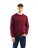 Buzo de punto liso color negro, con cuello redondo y puños y ruedo acanalados. Se lleva sobre una camisa celeste de vestir.