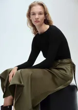Vestido midi de diseño evasé con cuerpo de lyocell negro de manga larga y cuello barco, combinado con una falda de poliéster en color verde oliva que incluye un cinturón decorativo integrado.