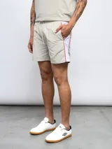 Short de baño negro con una banda vertical blanca en el lateral con el logo de Umbro en color rosa.