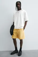 Bermuda de algodón gris con efecto lavado, corte relajado, cintura elástica ajustable con cordón y bolsillos laterales y trasero de vivo.